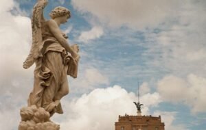 Statue on top of Castel Sant'Angelo in Rome against a blue sky